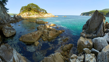 Sea coast with clear water. Stones and sea urchins at the bottom.