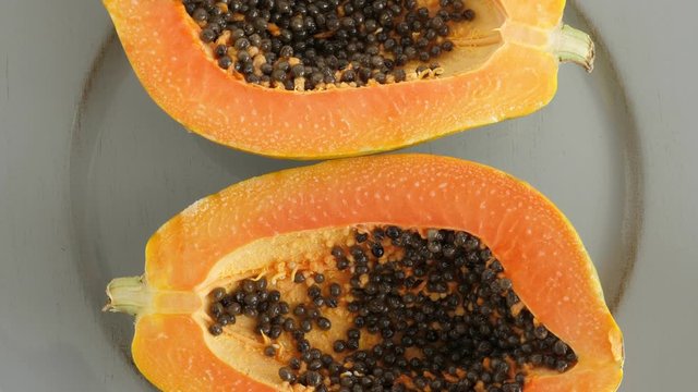 Top view of ripe half cut papaya. Rotating