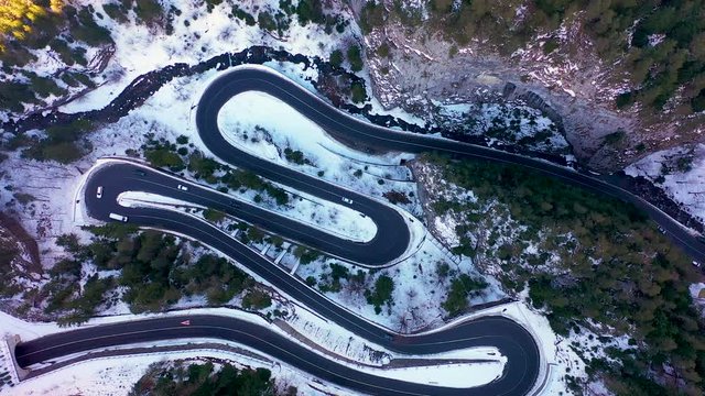 Aerial drone view of a serpentine in rocky mountain forest, Bicaz gorge with winding road in winter season,Cheile Bicazului, Romania