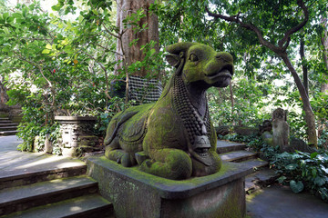 statue of a cow in the park covered with moss