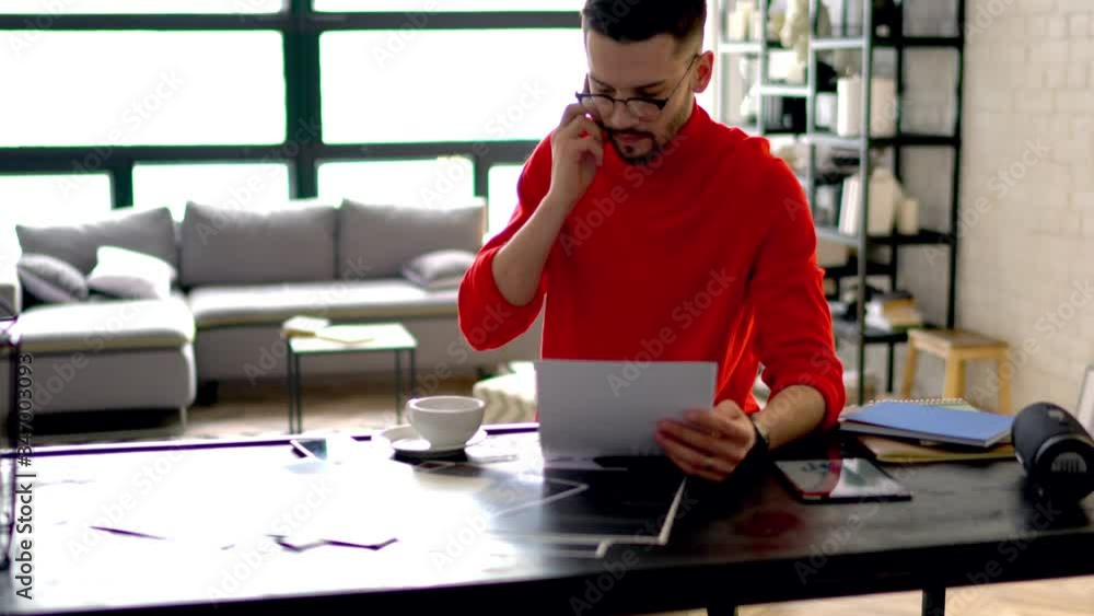 Poster young man designer dressed in casual wear calling on digital smartphone device and talking with mobi
