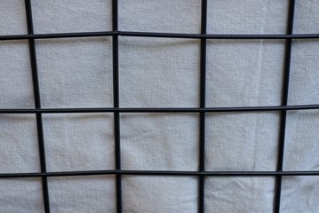 texture of black iron bars in a lattice on white matter
