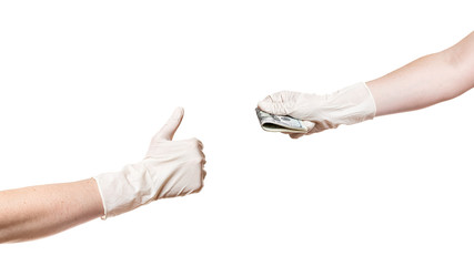 hands in sterile medical gloves concept on theme of corruption in medicine giving a bribe in cash dollars and show approving gesture class thumbs up, isolated on a white background with a copy space.