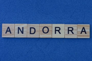 name of the country of Andorra from the word from gray wooden letters on a blue table