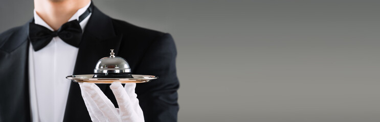 Midsection Of Waiter Holding Service Bell In Plate