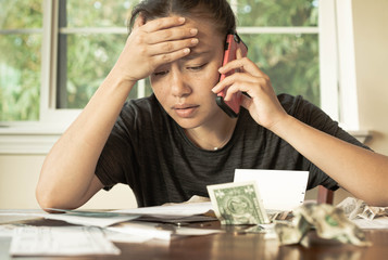 A stressed woman with no money looking at her credit card bills and monthly payments. Financial...