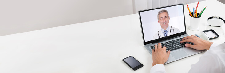 Businessperson Videochatting With Doctor On Laptop