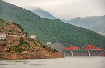 Shengli Street, China - May 6, 2010: Xiling gorge on Yangtze River. Red bridge links X210 and X239...