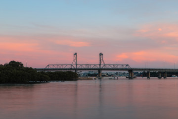 Fototapeta na wymiar Ryde Bridge over Parramatta River with pink sunset sky.