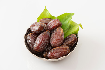 Palm dates on the silver plate, white background.
