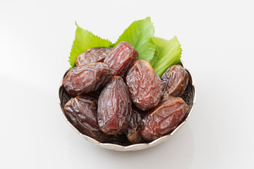 Palm dates on the silver plate, gray background.