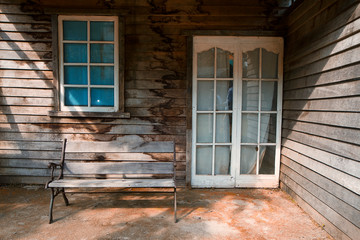 wooden bench in the terrace of old wooden house with window with shutters