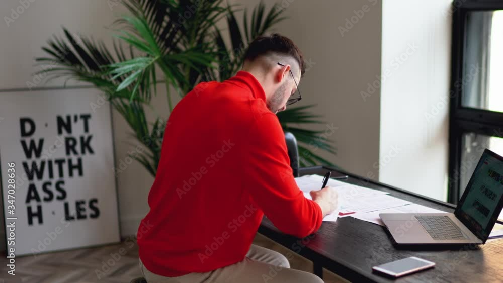 Poster bearded young businessman dressed in casual wear searching information on website on modern laptop c