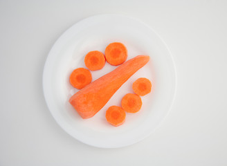 Fototapeta na wymiar fresh peeled carrots and sliced carrot slices on a white plate white isolated background