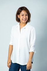 Portrait of Young Asian pretty cute cheerful business woman keeping arms crossed and smiling close up and looking at camera on white background. natural make-up, and white teeth