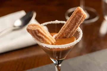 Tuinposter Mini churros with dulce de leche dessert on a glass © zequinao
