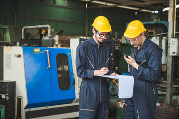 Industrial workers are working on projects in large industrial plants with many devices.