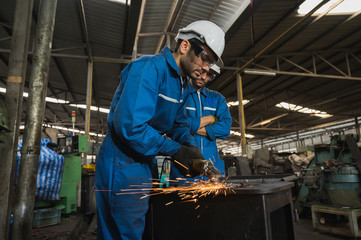 Industrial worker cutting metal and steel with many sparks