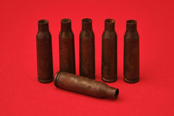 empty cartridges for the machine gun on a solid red background