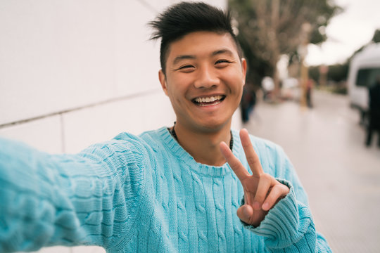Asian man taking a selfie.