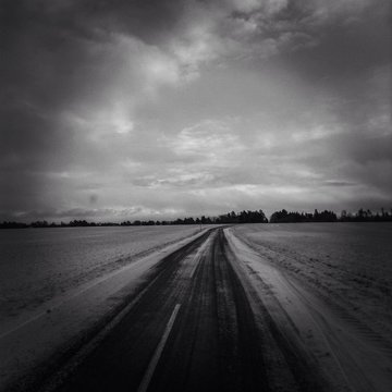 Road Amidst Snow Covered Field Against Cloudy Sky © marianne kastberg nielsen/EyeEm