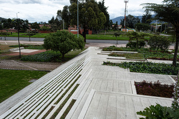 Naklejka premium Geometric pattern of a modern street stairways with green gardens, trees and nature architecture. A highway at background