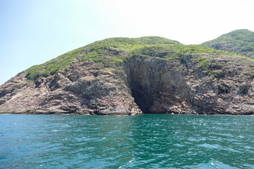 Huge hexagonal columnar joints of volcanic rock at Hong Kong Global Geopark, China, with cave made...