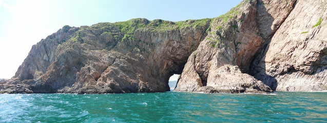 Huge hexagonal columnar joints of volcanic rock at Hong Kong Global Geopark, China, with cave made...