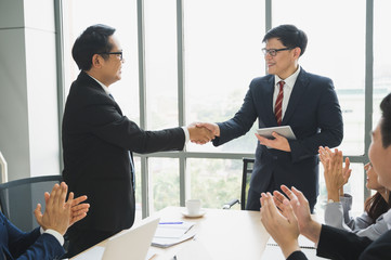 Asian business people team shaking hands for dealing sucess. Team of businesspeople shaking hands, finishing up meeting in office.