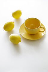 cup of tea with fresh yellow lemons on white background