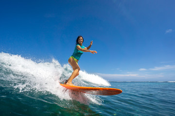 beautiful girl surfing on big transparent waves - obrazy, fototapety, plakaty