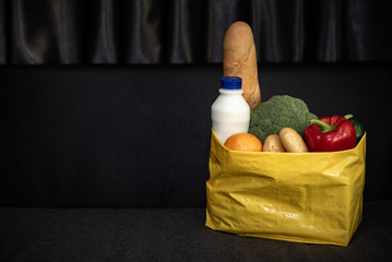 Fruits and vegetables dark background in a Kraft bag from the store. Healthy and healthy food from the farmers ' market. Space for text