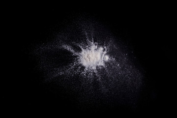 White powder explosion on black background.Stopping the movement of white powder on dark background. Launched white powder splash
