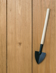 Shovel for digging soil on a wooden background.