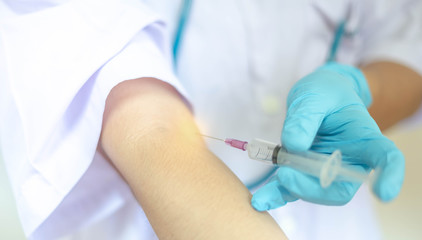 Doctor injecting drug dose into his arm by using syringe.  Drug addict injecting drugs concept.