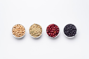 Bean bowls top view white background. These legumes are all pulses (dry edible plant seeds). The...