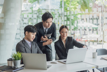 Young asian business people meeting and planning business strategies together in the office.