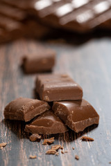 Close up of brown delicious and tasty milk chocolate bar on a wooden surface