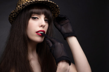 brunette in a hat with off the shoulder neckline. Studio portrait