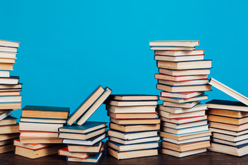 a lot of educational books for college exams on the blue background of the library