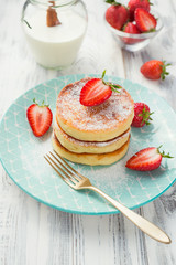 Cottage cheese pancakes with sliced strawberry on white background for breakfast.