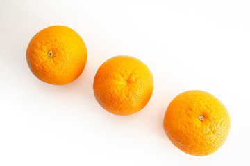 Three oranges on a white background top view