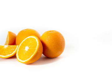 Three oranges on a white background one cut into three parts