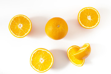 two whole and sliced orange on a white background top view