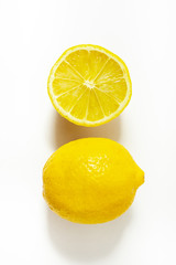 isolated lemon and half a lemon on a white background (hard light) top view