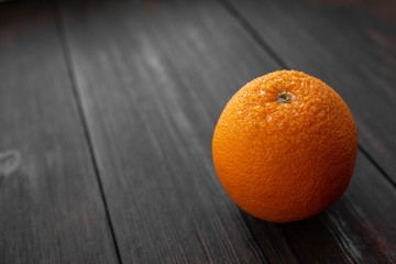 orange with drops of water on a dark wooden background