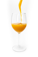 fresh orange juice is poured into a glass on a white background