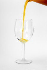fresh orange juice is poured into a glass on a white background