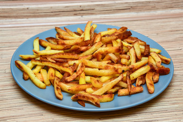 french fries on a blue plate on a wooden background