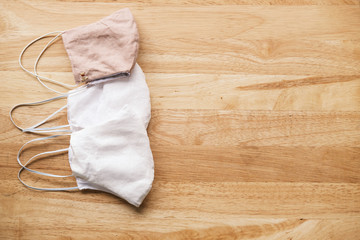 homemade white cloth masks for protection against coronavirus (COVID-19) on wooden table medium shot